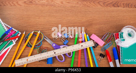 Bordure inférieure de un assortiment de fournitures scolaires on a wooden background with copy space Banque D'Images