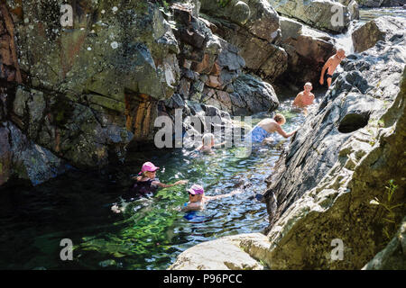 Les gens wild de nager dans une piscine en Langstrath rocheuses Beck sur une chaude journée d'été. Stonethwaite Borrowdale Parc National de Lake District Cumbria England UK Banque D'Images