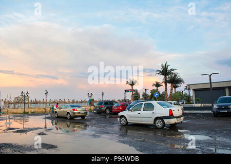 13 juillet 2018-Constanta, Roumanie. L'buidlings et terrasses après une tempête en bord de mer avec les rues inondées au coucher du soleil. Banque D'Images