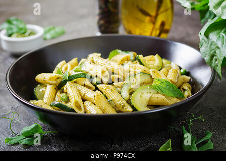 Pâtes penne au pesto, courgettes, pois verts et basilic. Cuisine italienne. Banque D'Images