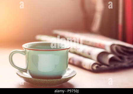 Tasse de dusty et journal sur le bureau. Banque D'Images