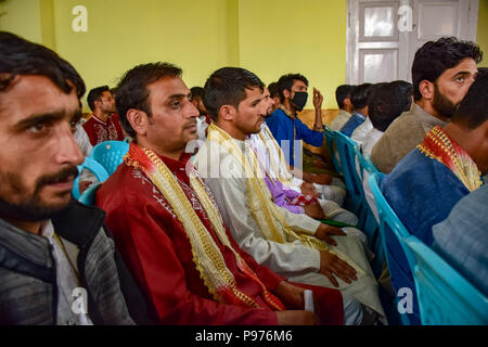 Srinagar, Inde. 15 juillet 2018. Musulmans du cachemire palefreniers s'asseoir pour un événement de mariage de masse à Srinagar, au Cachemire sous contrôle indien le dimanche. Mariage de masse de 105 couples musulmans tenue à Srinagar, organisé par l'organisation de la protection sociale principalement pour aider les familles économiquement arriéré qui ne peuvent pas se permettre le coût élevé de la cérémonie, de la dot et des cadeaux coûteux, qui prévaut encore dans de nombreuses communautés de l'Inde. Credit : SOPA/Alamy Images Limited Live News Banque D'Images