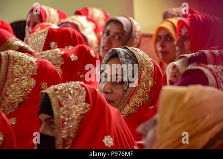 Srinagar, Inde. 15 juillet 2018. Les épouses de musulmans du Cachemire s'asseoir pour un événement de mariage de masse à Srinagar, au Cachemire sous contrôle indien le dimanche.mariage de masse de 105 couples musulmans tenue à Srinagar, organisé par l'organisation de la protection sociale principalement pour aider les familles économiquement arriéré qui ne peuvent pas se permettre le coût élevé de la cérémonie, de la dot et des cadeaux coûteux, qui prévaut encore dans de nombreuses communautés de l'Inde. Credit : Abbas Idrees SOPA/Images/ZUMA/Alamy Fil Live News Banque D'Images