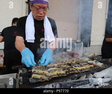 Tokyo, Japon. 14 juillet, 2018. Un employé de l'anguille japonaise restaurant et traiteur société Funachu les anguilles des grillades sur charbon de feu pour spitchcock ou anguille kabayaki au festival de l'anguille d'avance sur l'anguille-jour de consommation à Tokyo le samedi 14 juillet, 2018. Les Japonais ont une coutume de manger l'anguille grillée le jour de l'Ox, 'Doyou no ushi no hi' en plein été. Credit : Yoshio Tsunoda/AFLO/Alamy Live News Banque D'Images