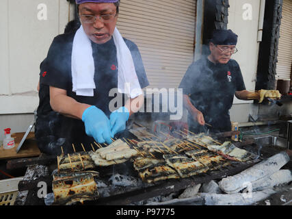 Tokyo, Japon. 14 juillet, 2018. Un employé de l'anguille japonaise restaurant et traiteur société Funachu les anguilles des grillades sur charbon de feu pour spitchcock ou anguille kabayaki au festival de l'anguille d'avance sur l'anguille-jour de consommation à Tokyo le samedi 14 juillet, 2018. Les Japonais ont une coutume de manger l'anguille grillée le jour de l'Ox, 'Doyou no ushi no hi' en plein été. Credit : Yoshio Tsunoda/AFLO/Alamy Live News Banque D'Images