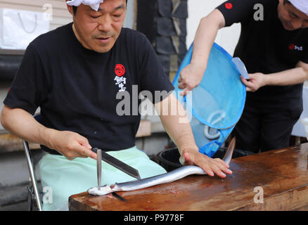 Tokyo, Japon. 14 juillet, 2018. Un employé de l'anguille japonaise restaurant et traiteur société Funachu découper une anguille pour spitchcock ou anguille kabayaki au festival de l'anguille d'avance sur l'anguille-jour de consommation à Tokyo le samedi 14 juillet, 2018. Les Japonais ont une coutume de manger l'anguille grillée le jour de l'Ox, 'Doyou no ushi no hi' en plein été. Credit : Yoshio Tsunoda/AFLO/Alamy Live News Banque D'Images