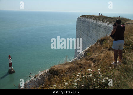 Beachy Head, UK - 14 juillet 2018 : vu sur Beachy Head surplombant la falaise Beachy Head Lighthouse 162 mètres au-dessous par une chaude journée d'été le 14 juillet 2018. Porté à des températures de 27 degrés et devrait rester élevé pendant un autre mois. La falaise, la plus haute falaise de craie en Grande-Bretagne s'élève à 162 mètres au-dessus du niveau de la mer et, malheureusement, l'un des plus fameux spots de suicide dans le monde. Crédit : David Mbiyu Banque D'Images