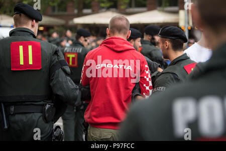 Stuttgart, Allemagne. 15 juillet, 2018. Football : Coupe du monde, la France contre la Croatie, Final. Les agents de police en tenant à l'écart un homme dans le Theodor Heuss Strasse. La France a battu la Croatie lors de la Coupe du Monde de la FIFA 2018 en Russie. La France est le nouveau Champion du Monde. Credit : Marijan Murat/dpa/Alamy Live News Banque D'Images