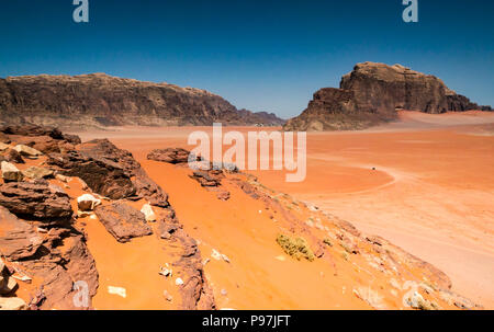 Véhicule 4x4 et les pistes dans de vastes étendues désolées, le Wadi Rum vallée avec montagnes, Jordanie, Moyen-Orient Banque D'Images
