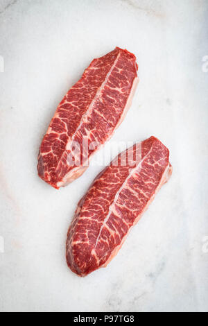 La viande fraîche crue lame supérieure steaks sur fond clair. Vue de dessus Banque D'Images