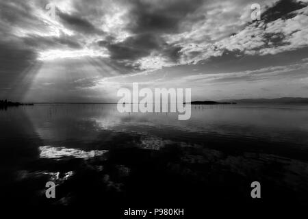 Parfaitement symétrique et vue spectaculaire d'un lac, avec des nuages, le ciel et les rayons du soleil reflétant sur l'eau Banque D'Images