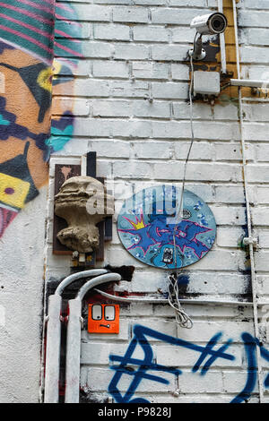 Berlin, Friedrichshain, MATIÈRES Gelände. Caméra de surveillance CCTV, street art et vieux câblage électrique sur l'extérieur de l'ancien bâtiment industriel Banque D'Images