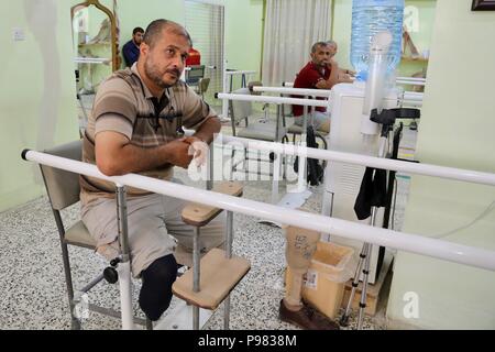 Mossoul, Irak. 15 juillet, 2018. Mohammad Abdullah pratiques pour marcher avec un membre artificiel dans un centre de réadaptation physique établi par le Comité international de la Croix-Rouge (CICR) à Erbil, Irak, le 11 juillet 2018. Par manque de lits d'hôpitaux et les salles d'urgence, d'un manque de la santé maternelle, de pédiatrie et de soins post-traumatique, des milliers d'habitants de Mossoul ont regagné leur patrie déchirée par la guerre. Credit : Khalil Dawood/Xinhua/Alamy Live News Banque D'Images