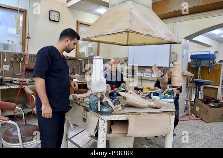 Mossoul, Irak. 15 juillet, 2018. Les ouvriers effectuent des membres artificiels dans un centre de réadaptation physique établi par le Comité international de la Croix-Rouge (CICR) à Erbil, Irak, le 11 juillet 2018. Par manque de lits d'hôpitaux et les salles d'urgence, d'un manque de la santé maternelle, de pédiatrie et de soins post-traumatique, des milliers d'habitants de Mossoul ont regagné leur patrie déchirée par la guerre. Credit : Khalil Dawood/Xinhua/Alamy Live News Banque D'Images