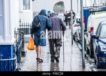 Pays de Galles Aberystwyth UK, lundi 16 juillet 2018 Royaume-Uni Météo : Après de nombreuses semaines de soleil presque constante et de temps exceptionnellement sec, les pluies ont renvoyé avec les gens obtenant trempé comme ils marchent le long de la promenade à Aberystwyth, sur la côte ouest du pays de Galles Crédit photo : Keith Morris Alamy Live News Banque D'Images