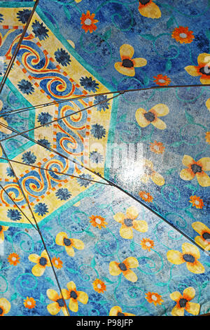 Un parasol à motifs érigée avec la lumière du soleil qui la traverse. Banque D'Images