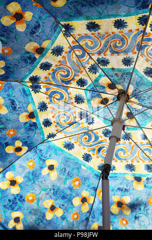 Un parasol à motifs érigée avec la lumière du soleil qui la traverse. Banque D'Images