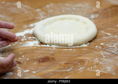 La pâte à pizza. Base pour la cuisson des pizzas sur une table en bois, close-up Banque D'Images