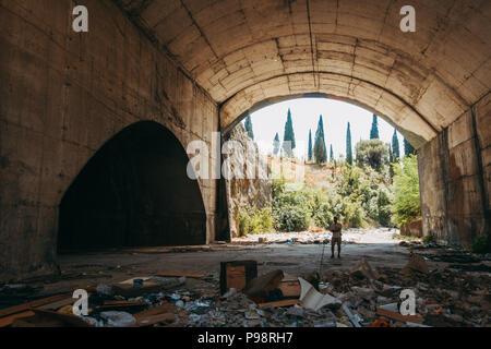 Le tourisme est à l'intérieur d'un hangar abandonné dans les montagnes à l'aéroport de Mostar, Bosnie-Herzégovine Banque D'Images