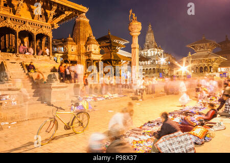 Lalitpur, Vallée de Katmandou, Népal : une longue exposition de vendeurs assis par leurs stands à l'Unesco figurant Patan Durbar Square de nuit. Banque D'Images