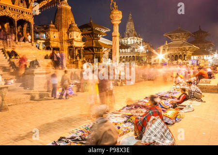 Lalitpur, Vallée de Katmandou, Népal : une longue exposition de vendeurs assis par leurs stands à l'Unesco figurant Patan Durbar Square de nuit. Banque D'Images