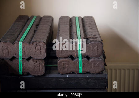 Un tas de briquettes de tourbe à côté d'un radiateur en Kilrush Irlande Banque D'Images