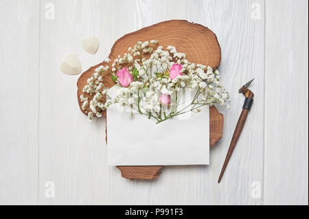 Plume calligraphique une enveloppe avec des fleurs et une lettre, carte de souhaits pour la Saint-Valentin avec place pour votre texte. Mise à plat, haut voir photo maquette Banque D'Images