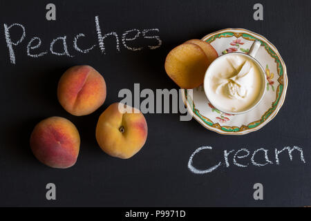 Pêches et crème avec un texte sur fond noir - chalk board haut voir photo Banque D'Images