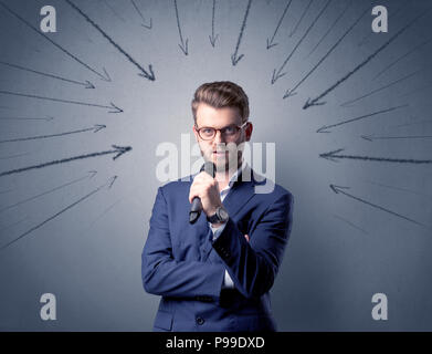 Businessman parlant au micro avec des flèches pointant vers la tête Banque D'Images