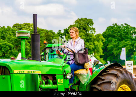 La productrice conduire un tracteur à la Northumberland County Show, Stocksfield, Northumberland, Angleterre. Banque D'Images