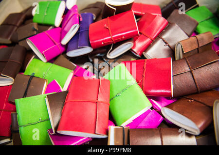 Des carnets en cuir faits main aux couleurs vives se sont empilés sur un marché dans la ville historique de Bath, en Angleterre, au Royaume-Uni Banque D'Images