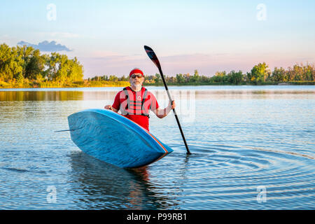 Portrait de l'environnement d'un pagayeur mâle avec un stand up paddleboard sur un lac calme dans le nord du Colorado, le paysage d'été Banque D'Images