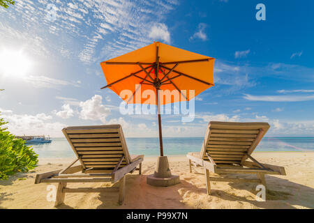 Locations dans les pays tropicaux. Chaises de plage, parasols et palmiers sur la plage Banque D'Images