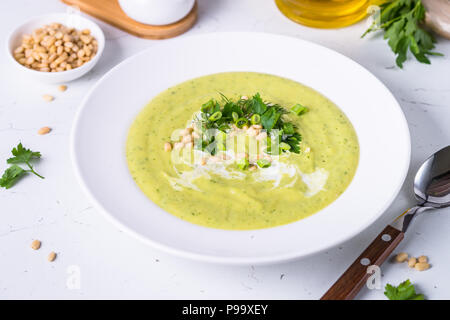 Soupe crème de courgettes aux herbes et pignons de pin. Alimentation nourriture, plat sans viande. Banque D'Images