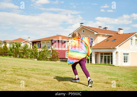 Teenage Girl Running avec cerf-volant coloré Banque D'Images