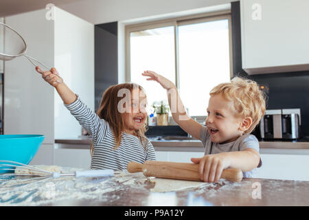 Drôles de petits enfants préparer la pâte pour les cookies dans la cuisine. Frères et sœurs des cookies et d'avoir du plaisir dans la cuisine. Banque D'Images