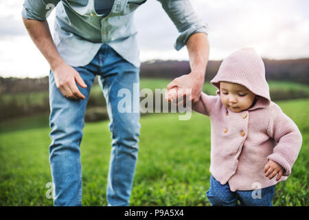 Un père avec son enfant fille à l'extérieur au printemps la nature. Banque D'Images