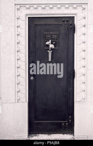 Chapelle du cimetière porte avec quelques fleurs Banque D'Images