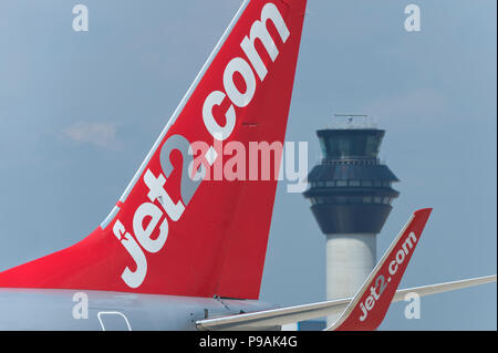 La tailfin d'un Boeing 737 Jet2 circule le long de la piste en face de la tour de contrôle à l'aéroport de Manchester. Banque D'Images