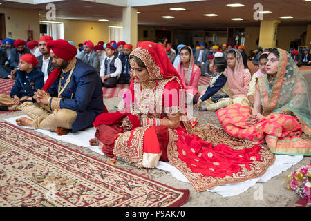 Les mariés à la modifier à leur cérémonie de mariage dans le temple à la Sikh Society à Richmond Hill, Queens, New York. Banque D'Images
