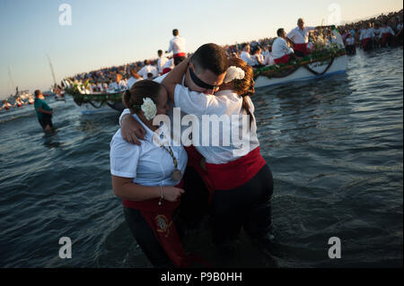 Malaga, Espagne. 16 juillet, 2018. Un homme bandeau est adoptée par une femme à la plage car ils participent à la traditionnelle procession de la Virgen del Carmen la fraternité. Chaque année, le 16 juillet, la ville de Malaga célèbre une fête religieuse en honneur de la Virgen del Carmen, patronne des marins et fishermans. Credit : ZUMA Press, Inc. Crédit : ZUMA Press, Inc./Alamy Live News Banque D'Images