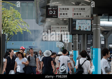 Kyoto, Japon. 17 juillet, 2018. Les gens à pied sous l'eau l'aérosol à la gare bus terminal à Kyoto, le 17 juillet 2018. Aujourd'hui, la température devrait atteindre 38 degrés Celsius (100 degrés) fahrenhiet à Kyoto, et augmenter le risque de coup de chaleur pour les gens. 17 Juillet 2018 Crédit : Nicolas Datiche/AFLO/Alamy Live News Banque D'Images