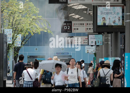 Kyoto, Japon. 17 juillet, 2018. Les gens à pied sous l'eau l'aérosol à la gare bus terminal à Kyoto, le 17 juillet 2018. Aujourd'hui, la température devrait atteindre 38 degrés Celsius (100 degrés) fahrenhiet à Kyoto, et augmenter le risque de coup de chaleur pour les gens. 17 Juillet 2018 Crédit : Nicolas Datiche/AFLO/Alamy Live News Banque D'Images