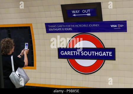 La station de métro Southgate. Le nord de Londres. UK 17 Juillet 2018 - Une femme prend une photo de l'affiche sur son téléphone mobile. L'échelon local, national et international de personnes visitent la station de métro Southgate pour prendre des photographies de la nouvelle enseigne qui a été fait en l'honneur de l'Angleterre football manager, Gareth Southgate, comme l'équipe nationale anglaise de football a terminé quatrième à la Coupe du Monde en Russie. Le signe qui remplace 'Southgate" au cours de la London Transport logo est pendant 48 heures seulement. Credit : Dinendra Haria/Alamy Live News Banque D'Images