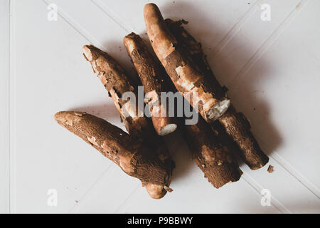 Le manioc (Manihot esculenta), mandioc, (espagnol : mandioca, Guarani : mandi'o) et non traités, les racines sur le tableau blanc, tons vintage, Asuncion, Paraguay Banque D'Images