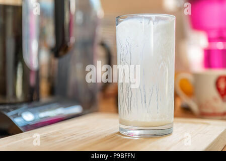 Vue rapprochée du verre vide de kéfir frais probiotik verre sur table de cuisine en bois Banque D'Images