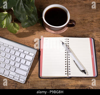 Vue supérieure de l'ordinateur portable ouvert sur un bureau en bois avec clavier de l'ordinateur et tasse de café Banque D'Images