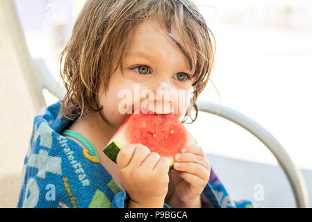 Une jeune fille avec un écran solaire sur sa tête à une pastèque mange waterpark en Pennsylvanie, aux États-Unis. Banque D'Images