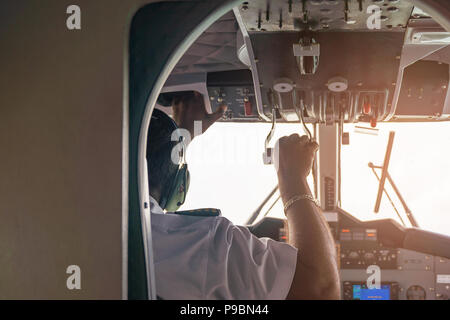 Détails de l'intérieur de l'avion avec pilote à bord pendant le vol, sur fond de ciel blanc. Banque D'Images