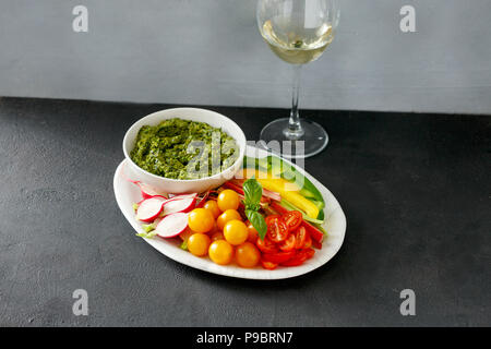 Des collations de légumes pour le vin avec sauce pesto et le verre de vin blanc Banque D'Images